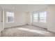 Bright bedroom with gray carpet, neutral walls, and two large windows at 16021 E 111Th Cir, Commerce City, CO 80022