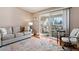 Living room with hardwood floors, neutral decor, and access to a private balcony at 750 S Clinton St # 12D, Denver, CO 80247