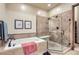 Bathroom with soaking tub, glass shower, and neutral tile at 7818 Vallagio Ln, Englewood, CO 80112