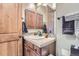 Small bathroom with sink, vanity, and wood cabinets at 7818 Vallagio Ln, Englewood, CO 80112