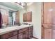Bathroom with sink, vanity, and wood cabinets at 7818 Vallagio Ln, Englewood, CO 80112
