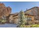 House exterior showcasing stonework, landscaping, and a two-car garage at 7818 Vallagio Ln, Englewood, CO 80112