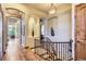 Elegant hallway with hardwood floors, curved staircase, and arched doorways at 7818 Vallagio Ln, Englewood, CO 80112