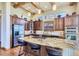 Gourmet kitchen with granite island, stainless steel appliances, and wood beams at 7818 Vallagio Ln, Englewood, CO 80112