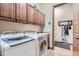 Laundry room with washer, dryer, cabinets, and access to additional storage at 7818 Vallagio Ln, Englewood, CO 80112