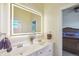 Bathroom with double vanity, large mirror, and access to bedroom at 3594 Palmer Ridge Dr, Parker, CO 80134