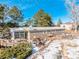 Tan mobile home with a deck and patio furniture in a winter setting at 567 Lake Gulch Rd, Castle Rock, CO 80104