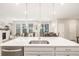 Kitchen island with white quartz countertop and stainless steel sink at 21382 E 60Th Ave, Aurora, CO 80019