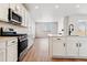 Open concept kitchen with island, stainless steel appliances, and white cabinets at 25025 E 41St Ave, Aurora, CO 80019