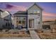 Two-story modern farmhouse with gray siding, stone accents, and a patio at 6183 Stable View St, Castle Pines, CO 80108