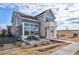 Modern farmhouse with gray siding, stone accents, and a spacious patio at 6183 Stable View St, Castle Pines, CO 80108