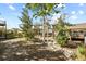 Landscaped backyard with trees, rock pathways, and a deck at 385 N Flat Rock St, Aurora, CO 80018