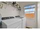 Laundry room with Whirlpool washer and dryer, and overhead shelving at 385 N Flat Rock St, Aurora, CO 80018