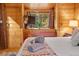 Cozy cabin bedroom with wood walls, dresser, and mountain views at 224 E Bakerville Rd, Idaho Springs, CO 80452