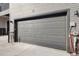 Attached one-car garage with a gray panel door at 455 Interlocken Blvd # 101, Broomfield, CO 80021