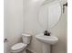 Small bathroom with pedestal sink, toilet, and oval mirror at 3184 Boral Owl Dr, Brighton, CO 80601