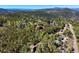 Mountaintop home surrounded by lush trees and distant mountain views at 10333 Georgia Cir, Morrison, CO 80465