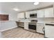 Updated kitchen featuring white cabinets and wood countertops at 5491 E Warren Ave # 218, Denver, CO 80222