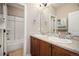 Bathroom with double vanity, large mirror, and tile shower at 26550 E Euclid Pl, Aurora, CO 80016