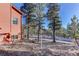 Red house exterior with a view of the driveway and surrounding trees at 31037 Witteman Rd, Conifer, CO 80433