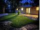 Landscaped backyard with a patio and lighting at night at 1355 Claremont Dr, Boulder, CO 80305