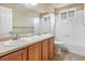 Bathroom with double vanity, tub, and neutral tile at 4050 S Odessa St, Aurora, CO 80013