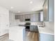 Modern kitchen with gray cabinets, white countertops, and stainless steel appliances at 13332 E 110Th Way, Commerce City, CO 80022