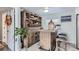 Home bar with wood cabinetry, shelving for glassware, and seating for two at 109 Wooster Dr, Firestone, CO 80520
