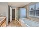 Bathroom with a shower, bathtub, and double sink vanity at 17404 E 99Th Ave, Commerce City, CO 80022