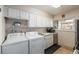 Efficient kitchen with white cabinets, stainless steel appliances, and laundry hookups at 8051 Wolff St # C, Westminster, CO 80031