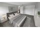 Main bedroom with grey bedding and double closets at 6800 E Tennessee Ave # 232, Denver, CO 80224