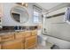 Clean bathroom with granite vanity, tiled shower, and large mirror at 920 Home Farm Cir, Denver, CO 80234