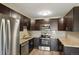 Modern kitchen featuring dark cabinetry and granite countertops at 725 S Clinton St # 7B, Denver, CO 80247