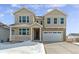 Two-story house with beige siding, a large garage, and a small porch at 654 Penn Rd, Elizabeth, CO 80107