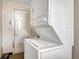 Stackable washer and dryer in a compact laundry room with an adjacent door at 2031 Meade St, Denver, CO 80211