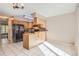 Eat-in kitchen with breakfast bar, wood cabinets, and black appliances at 1342 S Idalia St, Aurora, CO 80017