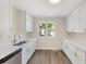 Bright kitchen with white cabinetry, dual basin sink, and windows offering natural light at 5144 Billings St, Denver, CO 80239