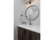 Modern bathroom with a round mirror, single vanity, and black fixtures at 3916 N Raleigh St, Denver, CO 80212