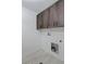 Laundry room with dark wood cabinets and white walls at 3916 N Raleigh St, Denver, CO 80212