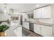 Modern kitchen with white shaker cabinets, stainless steel appliances and large island at 13359 W 71St Pl, Arvada, CO 80004