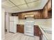 Kitchen with wood cabinets, white appliances, and vinyl floor at 13890 E Marina Dr # 111, Aurora, CO 80014