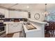Bright kitchen features white cabinets, stainless steel appliances, and an island with a breakfast bar at 8767 E Dry Creek Rd # 1312, Englewood, CO 80112