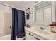 Clean bathroom with tub shower, vanity, and dark blue curtain at 8767 E Dry Creek Rd # 1312, Englewood, CO 80112