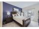 Comfortable bedroom with a dark-wood bed frame, nightstand, and large window at 8767 E Dry Creek Rd # 1312, Englewood, CO 80112