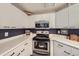 Modern kitchen with white cabinets, stainless steel appliances, and a corner sink at 8767 E Dry Creek Rd # 1312, Englewood, CO 80112