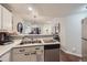 Open concept kitchen with white cabinets, double sink, and a view into the dining area at 8767 E Dry Creek Rd # 1312, Englewood, CO 80112