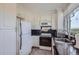 Kitchen features white cabinets, granite countertops, and stainless steel appliances at 1155 N Ash St # 1504, Denver, CO 80220