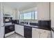 White kitchen with black countertops and stainless steel appliances, overlooking a city view at 1155 N Ash St # 1504, Denver, CO 80220
