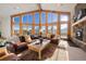 Spacious living room with a stone fireplace, large windows, and leather sofas at 2040 Kerr Gulch Rd, Evergreen, CO 80439