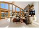 Living room with vaulted ceiling, stone fireplace, and expansive windows at 2040 Kerr Gulch Rd, Evergreen, CO 80439